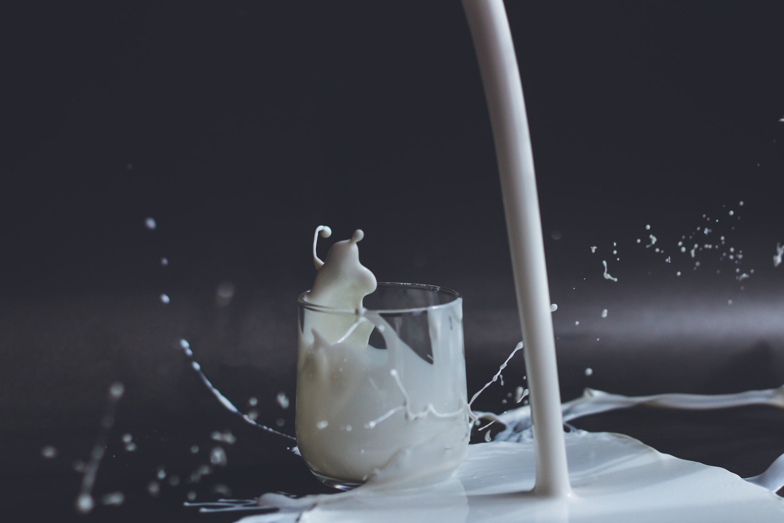 health benefits of dairy products milk splashing on ground next to glass of milk